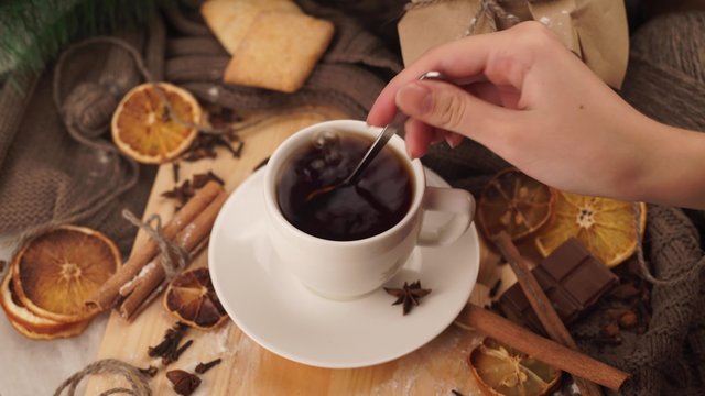 Hot winter tea in a white mug with a spoon stir the sugar Christmas
