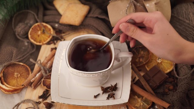 Hot winter tea in a white mug with a spoon stir the sugar Christmas