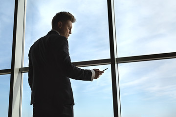 Stylish business man in the background of a large window 