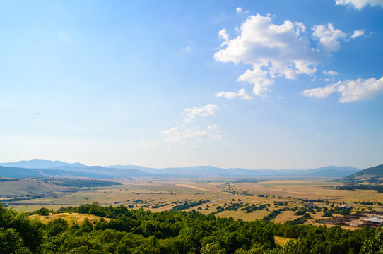 Rural landscape with bright blue sky with clouds and farmland