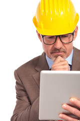 thoughtful construction engineer reading on his tablet pad
