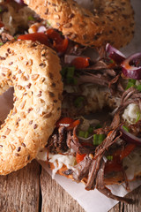 Bagel with vegetables and Pulled pork close-up. vertical
