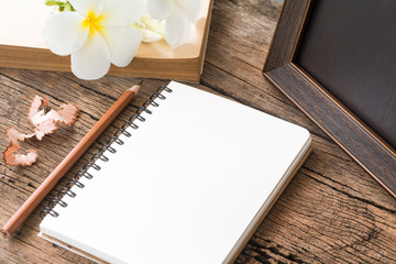 blank notebook with pencil on wooden table, business concept