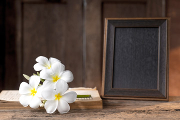 Fototapeta na wymiar bank picture frame on wood counter with white flower