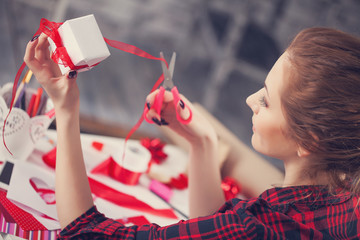 Woman creating gift at home with paper and gouache