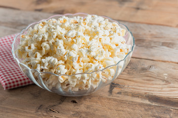 Popcorn in bowl on a wood table..