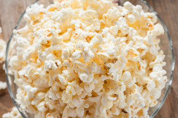 Bowl of popcorn on wood table. Top view.