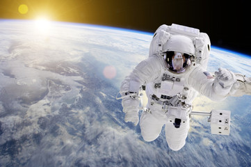 Astronaut in Space, in background our earth an the sun - Elements of this image furnished by NASA