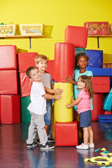 Kinder spielen in Turnhalle vom Kindergarten