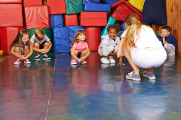 Kinder turnen in Turnhalle vom Kindergarten