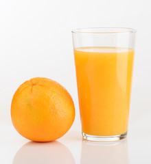 glass of orange juice and orange pieces