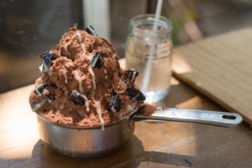 Shaved ice dessert topping with powder chocolate and cookie.
