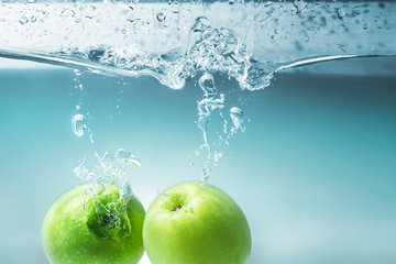 green apple dropping into water