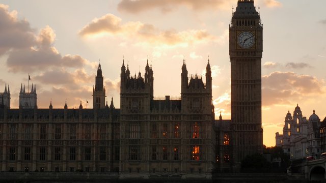 Tilt up from a passing river boat to Big Ben in London, at sunset. Shot in 4K