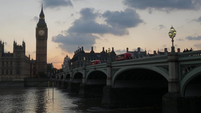  London buses cross Westminster Bridge at Sunset, stopping at Parliament. Shot in 4K