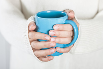 Cup of tea or coffee in female hands
