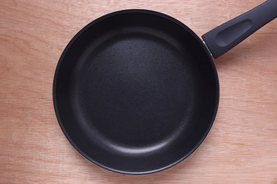 Empty Black Frying Pan on Wooden Background.