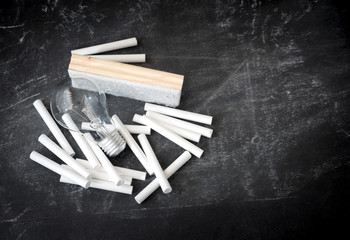 chalk and light bulb on blackboard