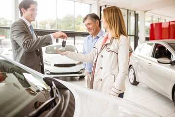 Obraz premium Salesman giving car key to a couple