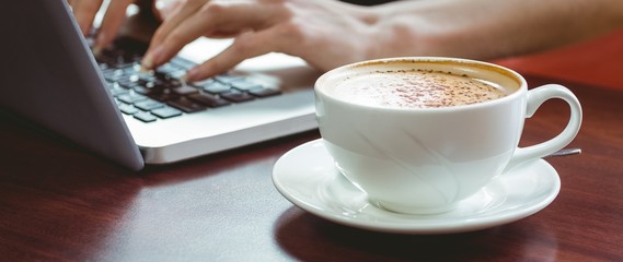 Mature student using laptop in cafe