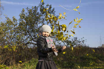 Dziewczynka bawiąca się liśćmi