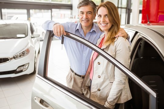 Smiling Couple Leaning On Car