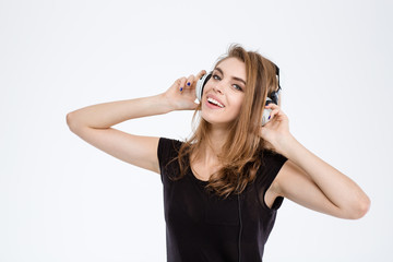 Cheerful woman listening music in headphones