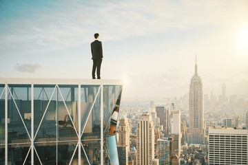 Businessman on the top of skyscraper looking at the city