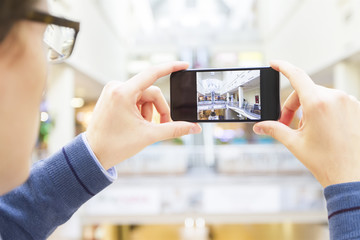 Man making a picture with smartphone in trade center