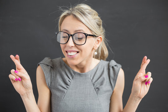 Young Cheerful Woman With Fingers Crossed