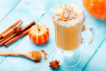 Pumpkin smoothie, spice latte with whipped cream. Turquoise wooden background.  