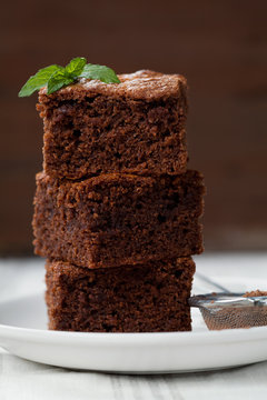 Closeup brownie stack, chocolate cake in plate on rustic wooden table