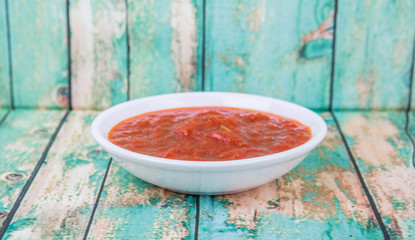 Spaghetti sauce in a white bowl over wooden background