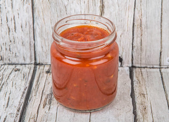 Spaghetti sauce in a mason jar over wooden background