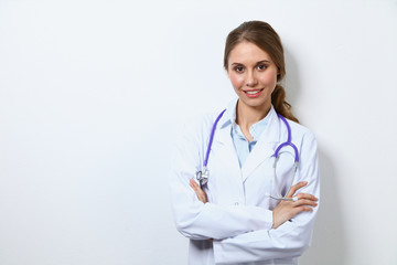 Friendly smiling young female doctor, standing near wall
