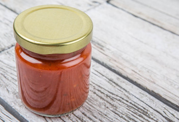 Spaghetti sauce in a mason jar over wooden background