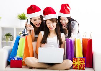young women watching laptop with christmas shopping concept