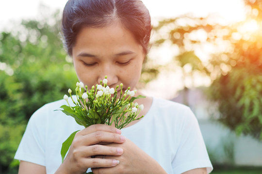 Asian Woman Smelling Flowers In Garden.