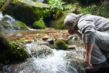man drinking fresh water from spring