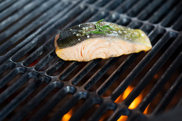 stages of cooking salmon on the grill - fresh fillet on gridiron