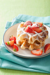 belgian waffles with icing sugar and strawberry