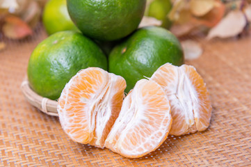 Group of fresh oranges in a basket on maple leaves background, with clipping path