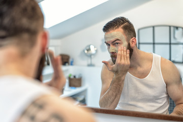 Mann mit Bart trägt eine Gesichtsmaske auf - obrazy, fototapety, plakaty