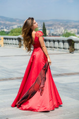 Beautiful brunette young woman wearing dress and walking on the street