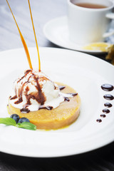 delicious dessert scoop of ice cream on a hot sherbet served on a white plate on a wooden table in a restaurant