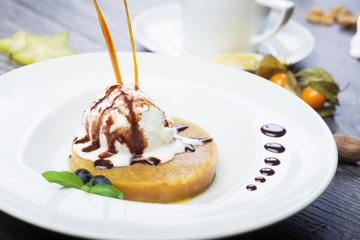 delicious dessert scoop of ice cream on a hot sherbet served on a white plate on a wooden table in a restaurant