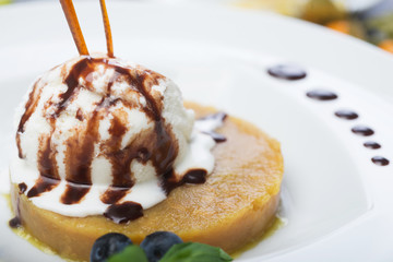 delicious dessert scoop of ice cream on a hot sherbet served on a white plate on a wooden table in a restaurant