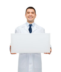 smiling male doctor holding white blank board