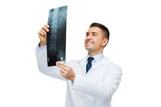 smiling male doctor in white coat looking at x-ray - Powered by Adobe