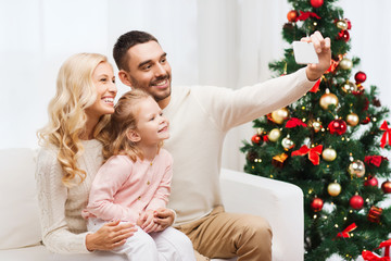 family taking selfie with smartphone at christmas